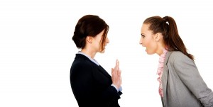 Two angry businesswomans arguing with eachother.