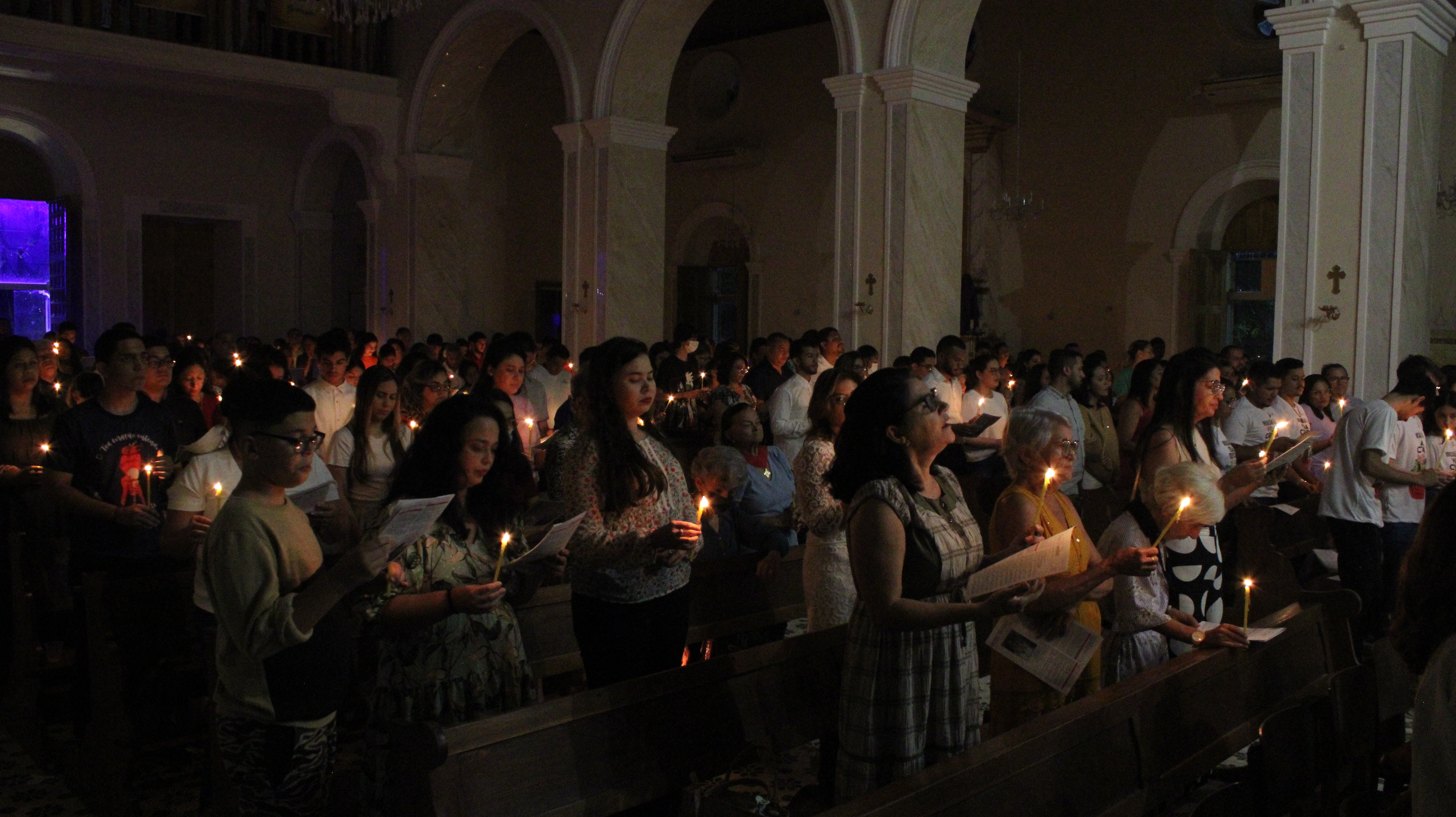 Fiéis renovando as promessas do Batismo durante a Vigília Pascal.