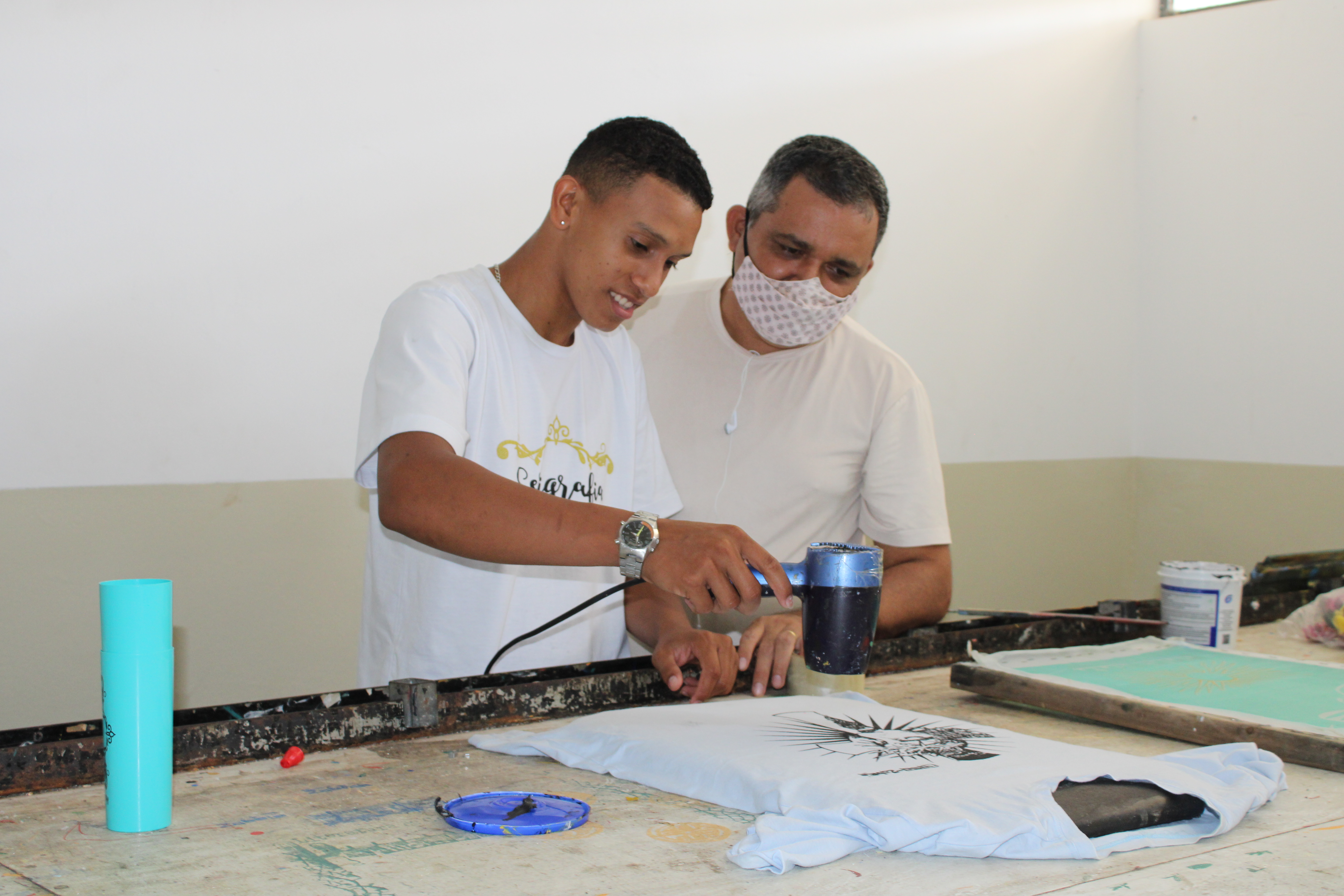 Aluno do Curso de Moda e Serigrafia da Casa de Zabelê confeccionando camiseta. 